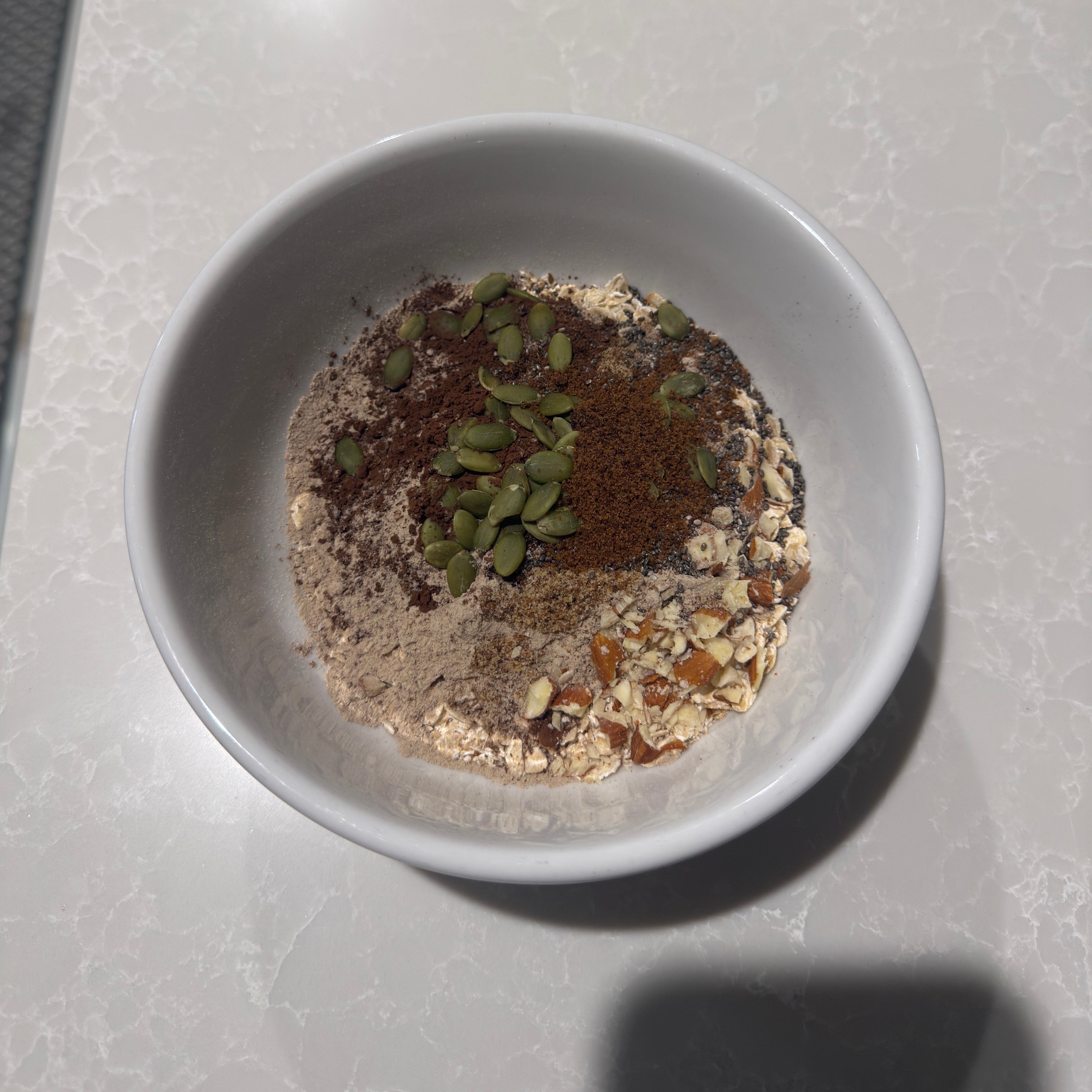 Fueledo Small bowl with a mixture of seeds and grains on a light surface