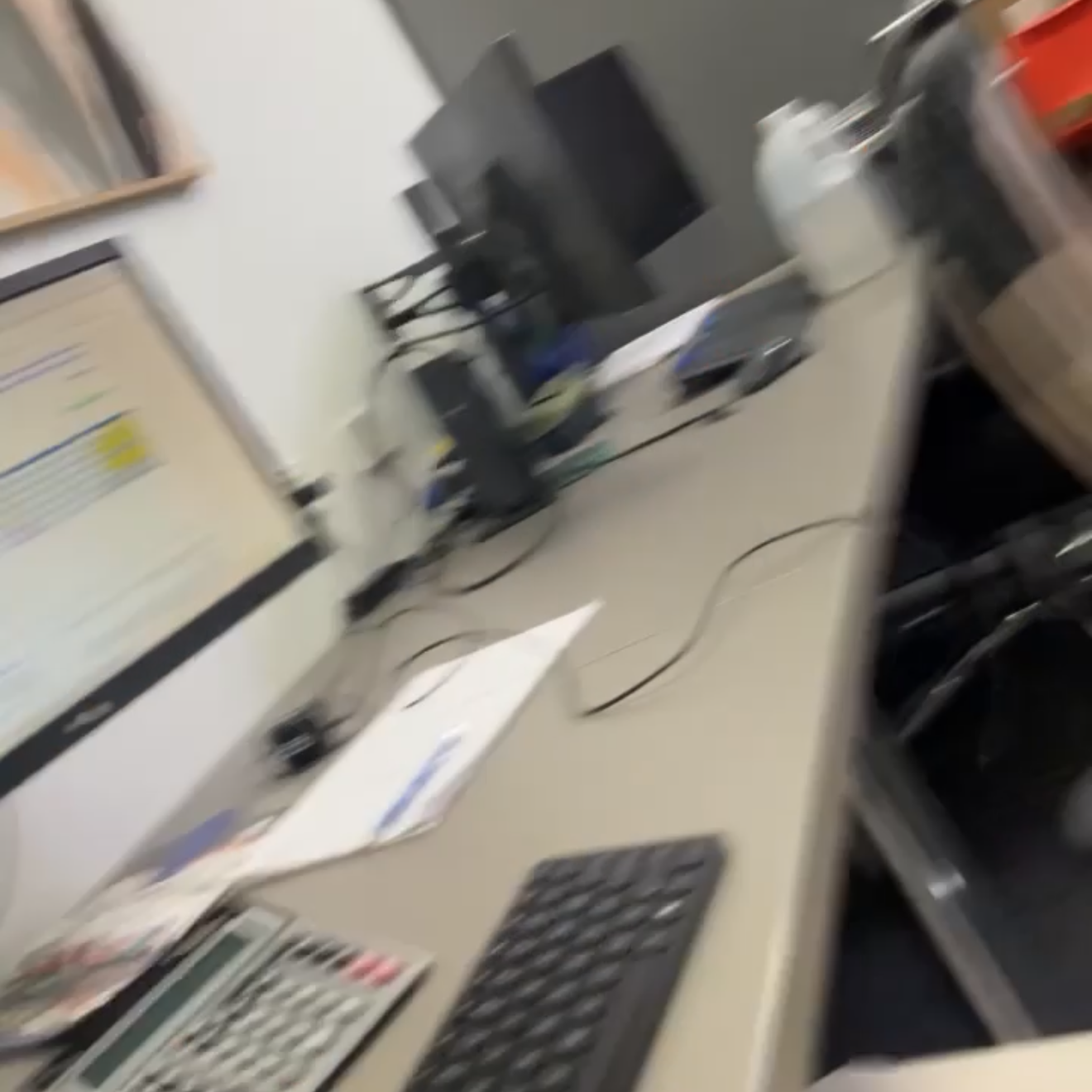 Computer desk with a keyboard, monitor, and office chair in an office setting.